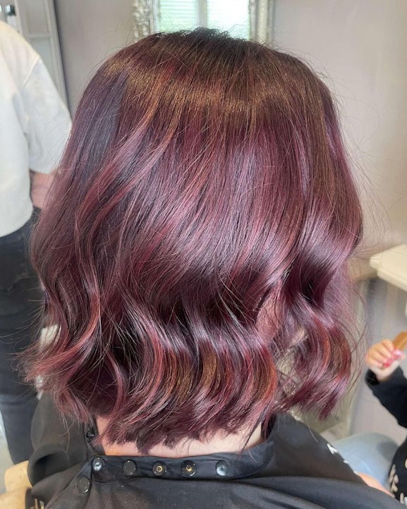 A short burgundy hairstyle with loose waves